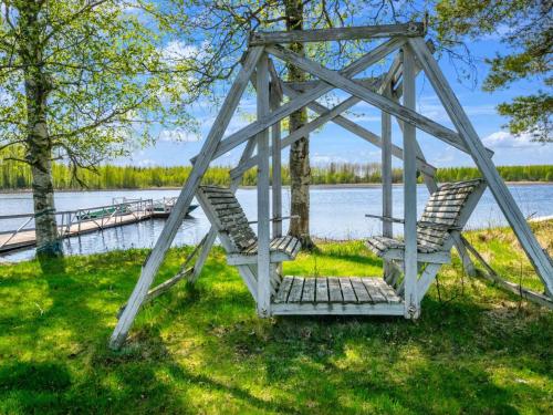 two chairs on a swing bridge over a lake at Holiday Home Tuliniemi by Interhome in Iisalmi