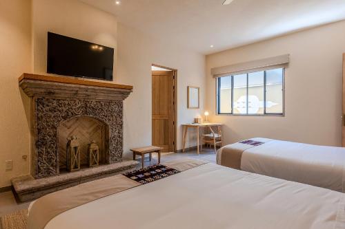 a bedroom with two beds and a fireplace at Designer Retreat in Centro Heated Pool & Views in San Miguel de Allende