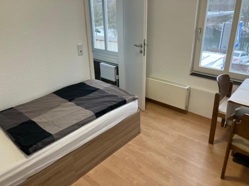 a small bedroom with a bed and a table at Hotel Lahnblick in Weilburg