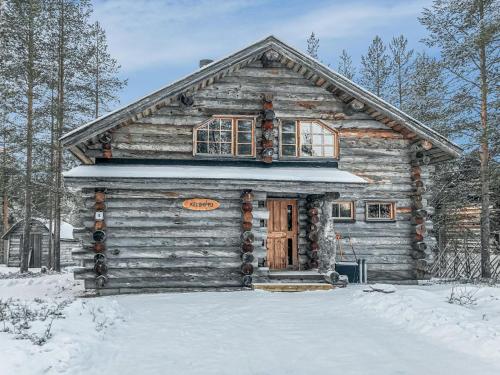 a log cabin in the snow with a door at Holiday Home Kelohippu 2 by Interhome in Pyhätunturi