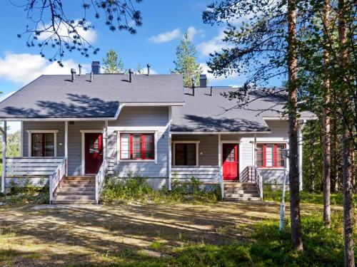 a house with red doors and trees at Holiday Home Kelkka 2 by Interhome in Salla