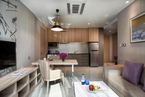 a kitchen and living room with a table and a couch at SKYVIEW Hotel Bangkok - Sukhumvit in Bangkok