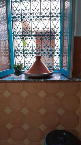 a window with a pot on a shelf next to a toilet at Dar Chamss in Taroudant