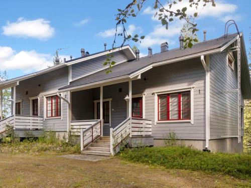 an old white house with red windows at Holiday Home Kelkka 1 by Interhome in Salla