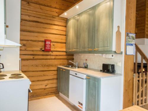 a kitchen with wooden walls and a sink and a counter at Holiday Home Kranni 2 by Interhome in Syöte