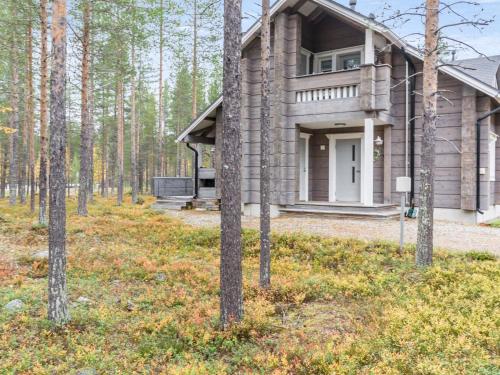 a wooden house in the woods with trees at Holiday Home Otsonherra by Interhome in Pyhätunturi