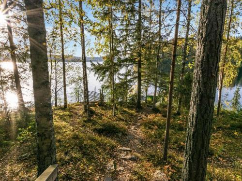 a path through the trees next to the water at Holiday Home Lossitupa by Interhome in Iitti