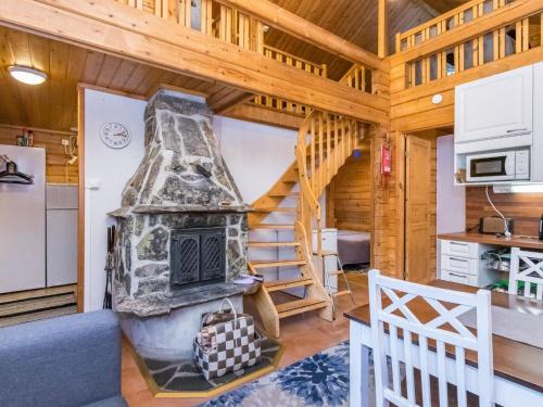 a log cabin with a fireplace and a staircase at Holiday Home Pyhä-vuonelo by Interhome in Pyhätunturi