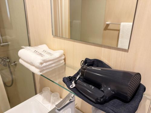 a black bag sitting on a glass table in a bathroom at なごらーれ放生津屋 in Shimminato