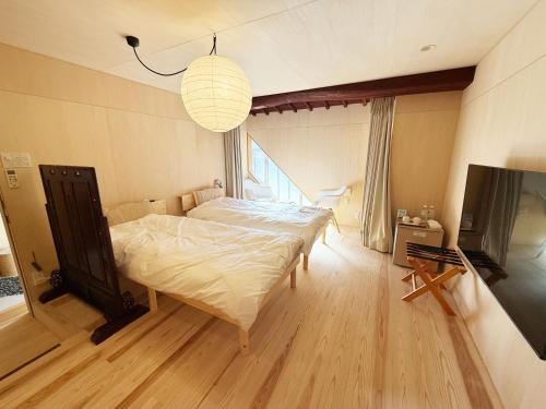 a bedroom with a large bed and a television at なごらーれ放生津屋 in Shimminato