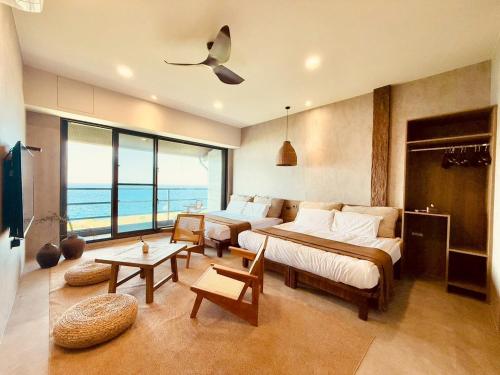 a bedroom with a bed and a room with a view of the ocean at Zenith Retreat in Xiaoliuqiu