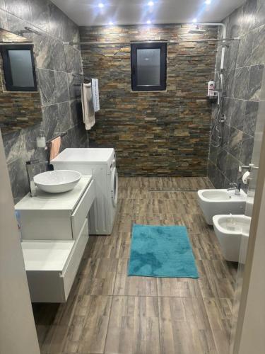 a bathroom with two sinks and a blue rug at Apartmen Emina in SJJ