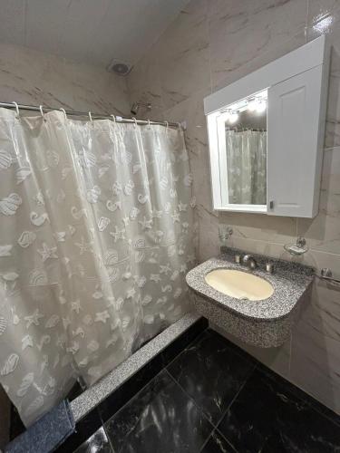 a bathroom with a sink and a shower curtain at El Atardecer in Trapiche