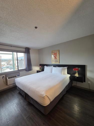 a bedroom with a large bed and a large window at The Baker Hotel in Cranbrook