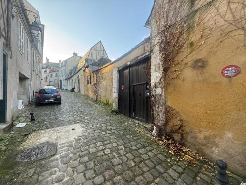 an alley with a car parked next to a building at La Galerie - Mini Piscine - Bourges Originale in Bourges