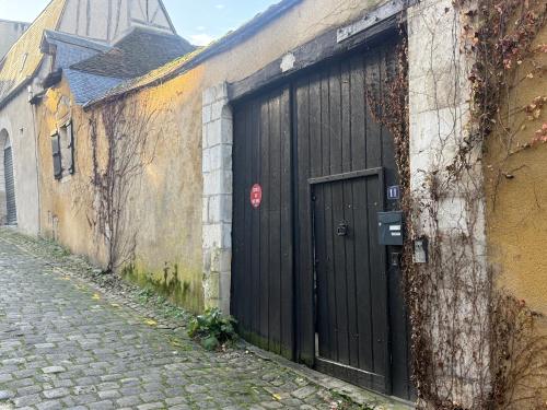a black door on the side of a building at La Galerie - Mini Piscine - Bourges Originale in Bourges