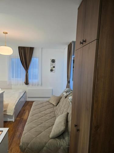 a bedroom with a bed and a large wooden cabinet at Sky Nest Kopaonik in Kopaonik