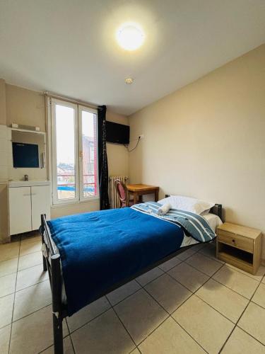 a bedroom with a bed with a blue blanket at Le Grand Café in Châtillon