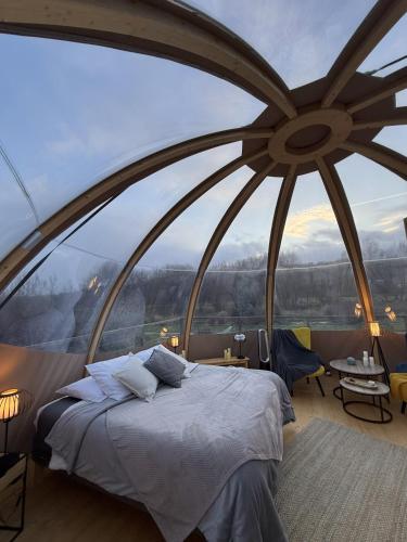 a bedroom with a large window with a bed at Wigwam Bel'Etoile in Bellencombre