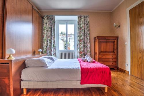 une chambre avec un lit avec une couverture rouge et une fenêtre dans l'établissement Le 38ème, à Périgueux