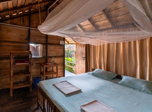 a bedroom with a bed in a wooden house at Blue Corner Beach Huts & Restaurant in Benaulim