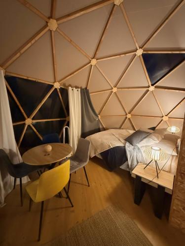 a room with a bed and a table and chairs at Dôme Bel'Etoile in Bellencombre