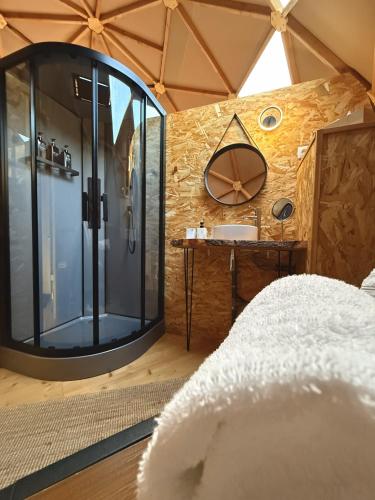 a bathroom with a glass shower and a sink at Dôme Bel'Etoile in Bellencombre