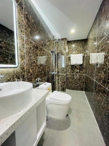 a bathroom with a toilet and a sink and a shower at Diamond Hotel CoLinh in Long Biên