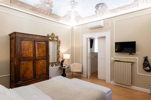 a bedroom with a bed and a tv on a ceiling at ViCity Orvieto, la Casa degli Affreschi e la Casa del Giardino Segreto in Orvieto