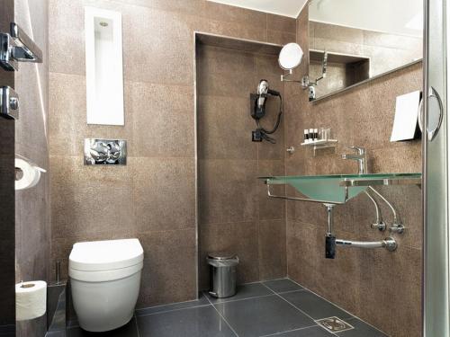 a bathroom with a toilet and a sink at Nova City Garni Hotel Signature Collection in Belgrade