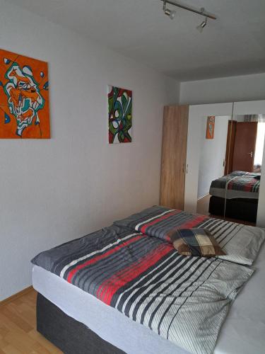 a bedroom with a bed with a striped comforter at Wasgauer Felsen und Seenland in Ludwigswinkel