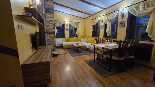 a living room with a table and a couch at Guest House Chepelare in Chepelare