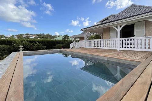 a swimming pool with a deck and a house at Villa Kazalou in Saint Martin