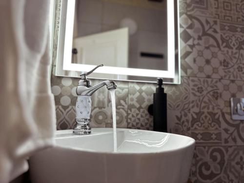 a bathroom with a sink with water coming out of it at Mandaraggio Stays in Victoria