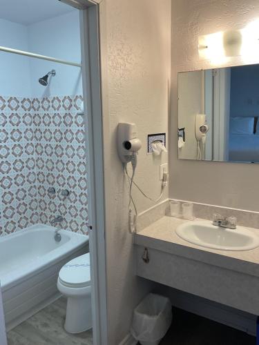 a bathroom with a sink and a toilet and a mirror at Motel Carleton Sur Mer in Carleton-sur-Mer