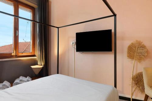 a bedroom with a bed and a flat screen tv at Mistral Holidays - Minisuite Centralissima in Marina di Carrara
