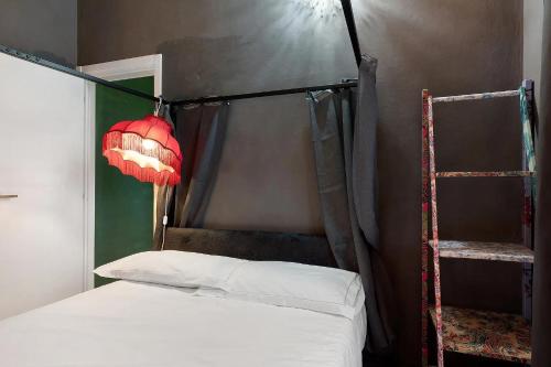 a bedroom with a bed with a canopy and a lamp at Mistral Holidays - Minisuite Centralissima in Marina di Carrara
