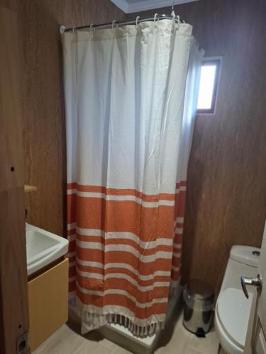 an orange and white shower curtain in a bathroom at My Refugio Wet Wet in Puerto Montt