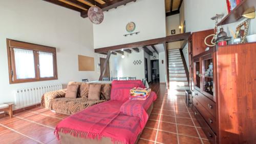 a living room with a couch and a red blanket at Rioja en calma in Villalobar de Rioja