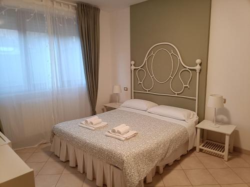 a bedroom with a bed with two towels on it at La casetta di Nonno Carlo a due passi dall'ospedale in Torrette