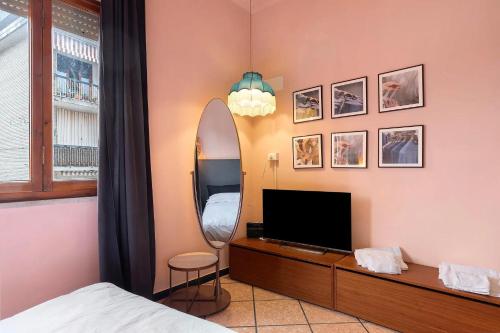 a bedroom with a bed and a mirror and a tv at Mistral Holidays - Minisuite con Terrazzino in Marina di Carrara