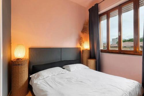 a bedroom with a large bed with two windows at Mistral Holidays - Minisuite con Terrazzino in Marina di Carrara