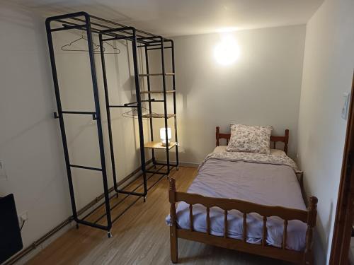 a bedroom with a bed and two metal shelves at maison Le Wetz in Sainte-Marie-Kerque
