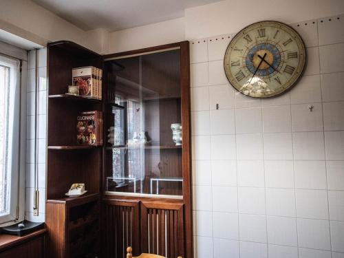 a clock hanging on a wall next to a shelf at Frank & Giuly House in Rivoli