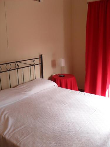 カターニアにあるCasalelloのベッドルーム(白いベッド1台、赤いカーテン付)