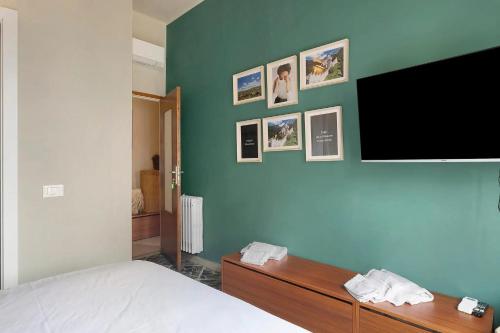 a bedroom with a flat screen tv on a green wall at Mistral Holidays - Minisuite Marina in Marina di Carrara