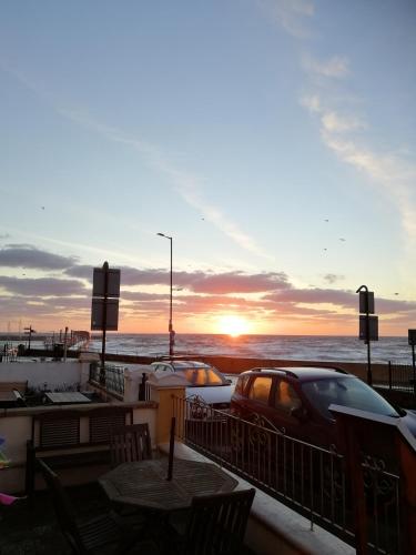 a car parked next to a pier with the ocean at Rowntree Seaview Holiday Apartments in Bridlington