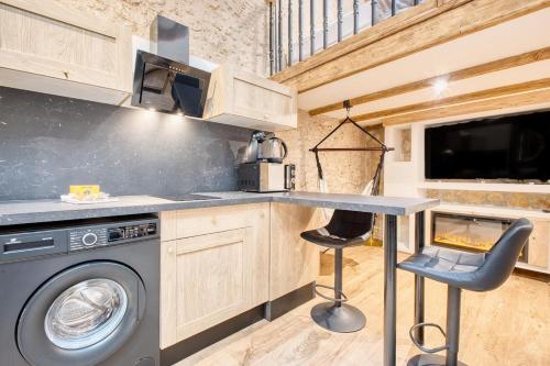 a kitchen with a washer and dryer in a tiny house at La bulle étoilée in Périgueux