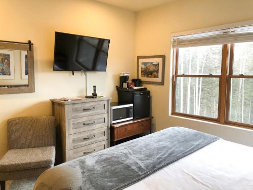 a bedroom with a bed and a flat screen tv at Bear Creek Lodge 209C in Telluride