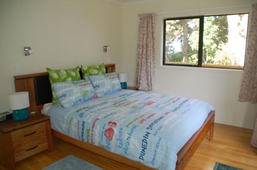 a bedroom with a bed and a window at Kohinui Glade Holiday Cottage in Parua Bay
